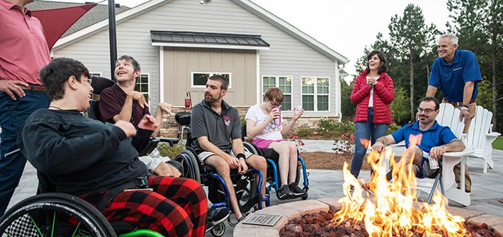 volunteers with special needs people near a bonfire